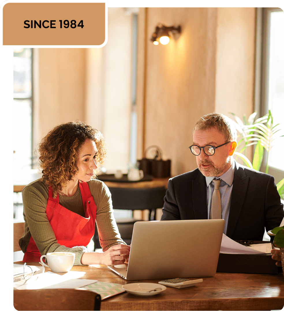 Two people discussing work at a laptop.
